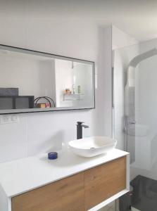 ein weißes Badezimmer mit einem Waschbecken und einem Spiegel in der Unterkunft Les Hirondelles Archiac in Archiac