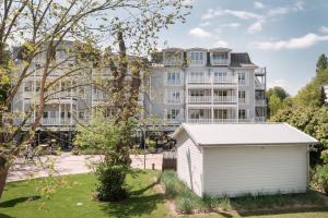 a large building with a white garage in front of it at The Cozy Hotel & Lofts Timmendorfer Strand in Timmendorfer Strand