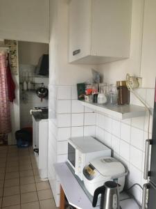 una pequeña cocina con encimera y microondas en Chambre ensoleillée et lumineuse en Orly