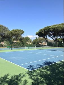 a tennis court with trees in the background at GASETIENNE Mazet T2 dans domaine avec piscines et tennis in Gassin