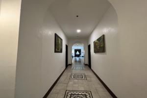 - un couloir avec des murs blancs et du carrelage dans l'établissement NSCC Casa De Vigan, à Vigan