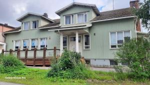 a green house with a wooden fence at Oulun Satamahuoneet in Oulu