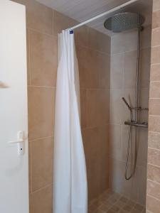 eine Dusche mit einem weißen Duschvorhang im Bad in der Unterkunft Les granges du chiron in La Garnache
