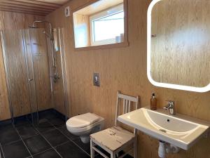a bathroom with a sink and a toilet and a mirror at Modern Rorbu Ryten 1 in Sund