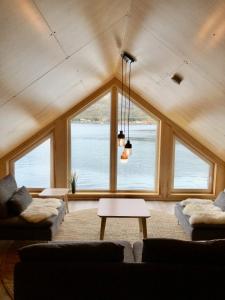 a living room with a large window with a view of the water at Fjordview Ryten 1 Retreat in Sund