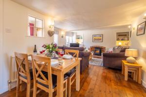 a dining room and living room with a table and chairs at Three Tuns Cottage in Little Walsingham