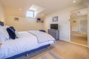 a bedroom with a bed and a television in it at Three Tuns Cottage in Little Walsingham