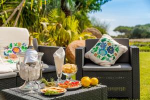 un patio con una mesa con una botella de vino y comida en Villaggio Cala Ginepro Resort & SPA, en Orosei