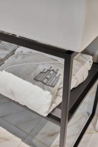 une pile de serviettes assises sur une étagère métallique dans l'établissement Brera Boutique Suites Milano, à Milan