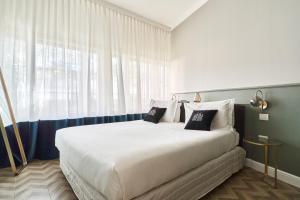 duże łóżko w pokoju z dużym oknem w obiekcie Brera Boutique Suites Milano w Mediolanie