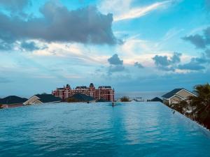 a swimming pool with a resort in the background at La Mer Villa in Bình Tú +13 photos
