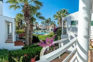 a balcony with palm trees and flowers at Villa Blanc in Sa Caleta