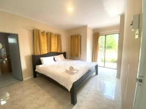 1 dormitorio con cama y ventana grande en Baan Golden Resort en Sam Roi Yot