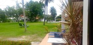 vistas a un patio con sillas y un parque en Baan Golden Resort en Sam Roi Yot