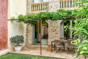 a patio with a table and chairs under a pergola at Casa vacacional Slow con piscina in Riumors