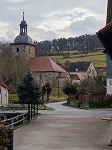 uma igreja com uma torre com um relógio em Ferienwohnung Papperitz em Heiligen