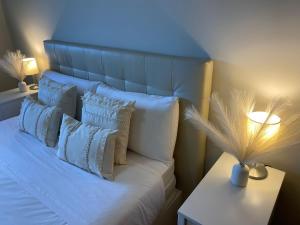 ein Schlafzimmer mit einem weißen Bett mit Kissen und einer Lampe in der Unterkunft Playa Pacífico Apartment in Málaga