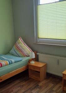 a bedroom with a bed with a lamp and a window at Panoramablick vom Obergeschoß in Geislingen an der Steige