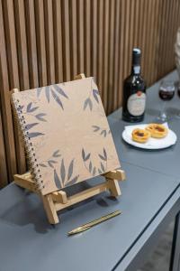 a wooden chair sitting on a table with a bottle of wine at Boavista Executive Studios in Porto