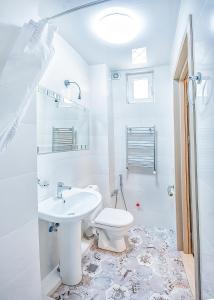 Un baño blanco con inodoro y lavabo. en Apartment #5, en Tiflis