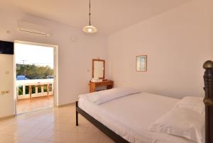a bedroom with a bed and a mirror and a balcony at PALEOCHORA FINIKAS Apartments in Palaiochóra