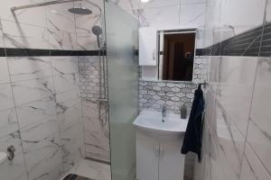 a white bathroom with a sink and a shower at Youthful Vibes near University, Free Parking in Ruse