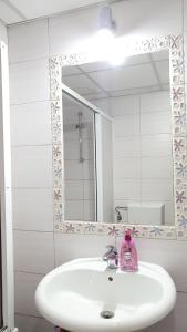 un lavandino in bagno con una bottiglia di sapone rosa di Apartments Nela a Ohrid
