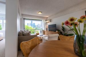 a living room with a vase of flowers on a table at Riverside apartment with city & Story Bridge view in Brisbane