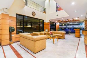 a lobby with couches and a clock on the wall at Super Capital O Hotel Grand Plaza in Coimbatore