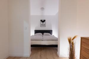 um quarto com uma cama num quarto branco em Luxus-Neubauvilla am Tierpark em Alsdorf