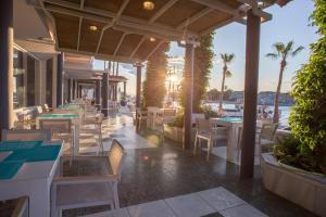 a restaurant with tables and chairs and a view of the water at Kosta Palace in Kos