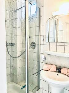ein Bad mit einer Dusche und einem Waschbecken in der Unterkunft Haus Deitje in Borkum