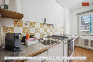 a kitchen with a sink and a microwave at Apartment in the heart of Oerlikon in Zurich