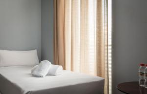 a bed with two towels on it next to a window at Hotel Madanis in Barcelona