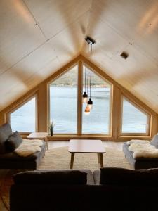 una sala de estar con una gran ventana con vistas al agua en Modern Rorbu Ryten 2, en Sund