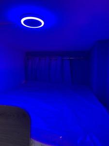 a blue room with a bed and a blue light at The sunset haven in Dubai