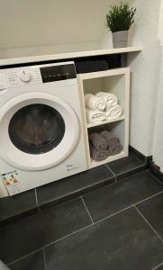 eine Waschmaschine und ein Trockner mit Handtüchern auf einem Regal in der Unterkunft ST-Apartment Charming 2 Dachgeschoss, 3 Zimmer in Geislingen in Geislingen an der Steige
