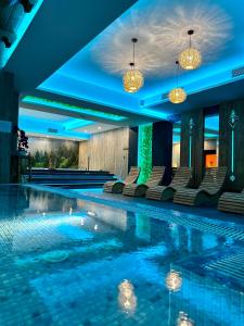 una piscina en un hotel con sillas y luces en Hotel Maria & Spa, en Szczawnica