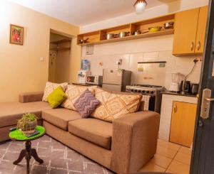 a living room with a couch and a kitchen at Sherry Homes - Raha in Nairobi