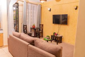 a living room with a couch and a flat screen tv at Sherry Homes - Raha in Nairobi