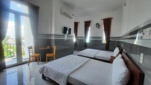 Tràm Chim的住宿－VIEW HOTEL-TRÀM CHIM，一间卧室设有两张床、一张桌子和一个窗口
