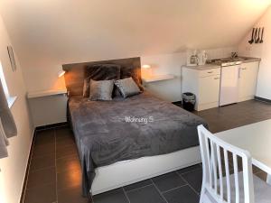 een slaapkamer met een bed en een kleine keuken bij Eschen´s Blick in Aurich