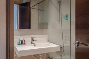 a white bathroom with a sink and a shower at Hotel Madanis in Barcelona