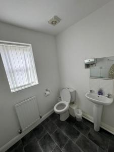 a white bathroom with a toilet and a sink at Manchester Home near Near City center and Stadium in Manchester