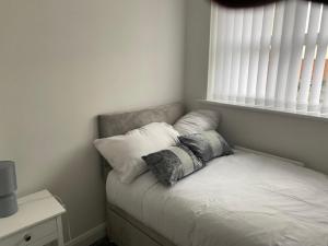 a bed with two pillows on it in a room at Manchester Home near Near City center and Stadium in Manchester