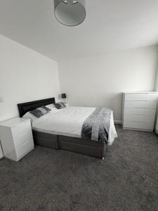 a bedroom with a bed and two white cabinets at Manchester Home near Near City center and Stadium in Manchester