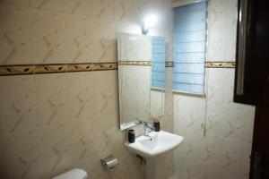 a bathroom with a sink and a mirror at EXECUTIVE MASTER BEDROOM in Accra