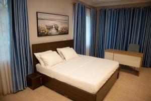 a bedroom with a bed with blue curtains at EXECUTIVE MASTER BEDROOM in Accra