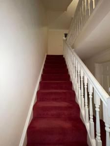 una escalera de moqueta roja en una casa con alfombra roja en Room 2 - Chassagne Guest House, en Church Coppenhall