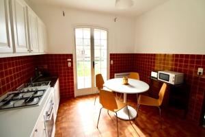 a kitchen with a white table and red tiles at Luberon Large House 4 bedrooms in La Tour-dʼAigues